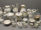 a lot of white and gold china on a table