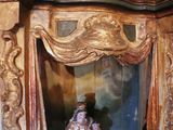 a figurine of a woman sitting in a wooden display case