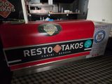 a red counter with a sign on it that says resto takos