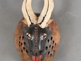 an image of a wooden mask with horns on it