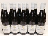 six bouteilles de vin sont alignées sur une table