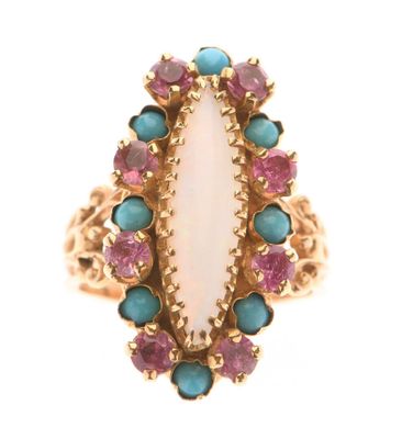 un gros plan d'une bague ornée d'une pierre blanche entourée de pierres roses et bleues