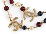 an image of a necklace with pearls and gold birds on it