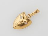 une image représentant un pendentif en forme de masque doré sur fond blanc