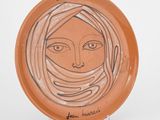 une assiette sur laquelle est représenté le visage d'une femme