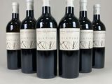 six bottles of wine are lined up in a row on a table