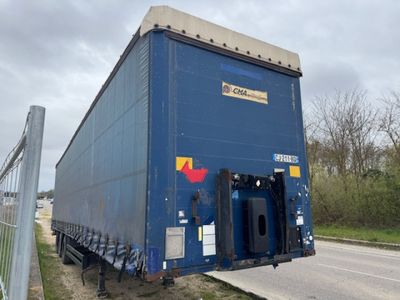 un gros camion bleu garé sur le bord de la route