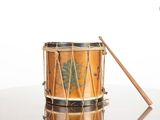 a small drum with a wooden stick on a table
