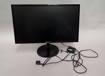 un écran d'ordinateur et un chargeur posés sur une table