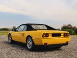a yellow sports car parked in a parking lot next to a field