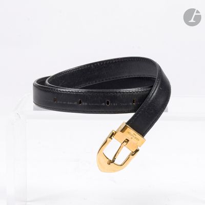 ceinture en cuir noir avec boucle dorée, présentée dans un coffret en acrylique transparent