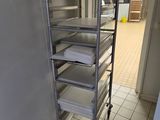 a metal rack with several trays of food on it