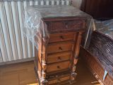 a bed and a dresser in a room with a wallpapered wall