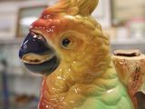 a colorful bird that is sitting on top of a vase