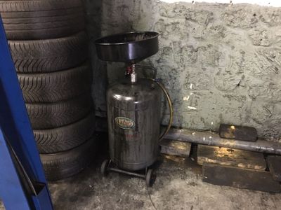 une pile de pneus à côté d'une bonbonne de propane dans un garage