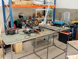 un établi au milieu d'une pièce, sur lequel se trouvent de nombreux outils