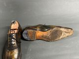 pair of leather shoes sitting on top of a gray surface