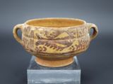 une image représentant un vase marron et jaune posé sur un socle transparent