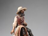 a figurine of a man sitting on top of a rock