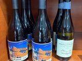 Plusieurs bouteilles de vin sont alignées sur une étagère dans un placard