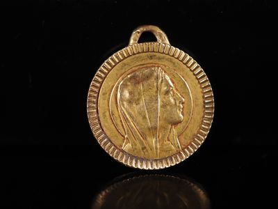 gros plan d'une pièce d'or portant un visage de femme