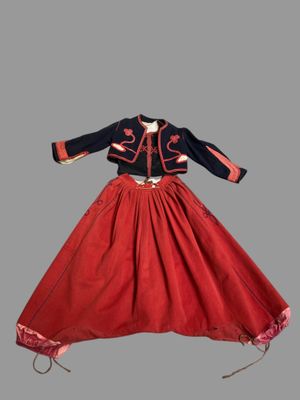 une robe rouge et bleue, avec une veste noire et une jupe rouge