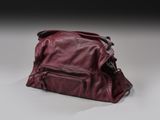 sac à main en cuir posé sur une surface blanche, sur fond noir