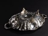 an antique silver plate with two birds on it on a black background