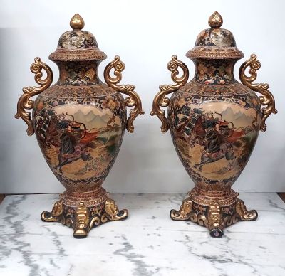 une paire de vases anciens posés sur une table en marbre rehaussée de touches dorées