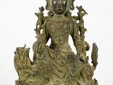 une image représentant une statue en bronze d'une femme assise sur un lotus