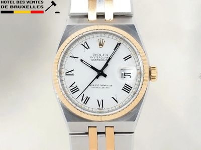 une montre blanche et dorée ornée de chiffres romains