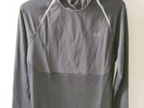 Le t-shirt est gris et comporte une capuche.