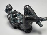 sculpture représentant une femme allongée sur le dos sur une surface blanche
