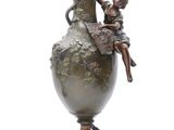 statue of a woman sitting on a vase with a child on it