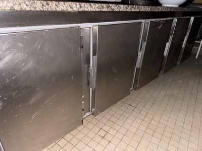 des meubles en acier inoxydable dans des toilettes publiques, avec une cuvette posée sur le plan de travail