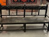 un banc qui se trouve dans une pièce où un tapis est accroché au mur