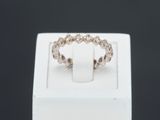 un gros plan d'une bague posée sur une boîte blanche, sur fond noir