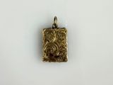 un petit pendentif en or orné d'un motif floral