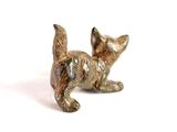 small bronze figurine of a cat on a white background