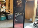 a tall black cabinet with a clock on top of it