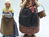deux figurines représentant des personnes debout l'une à côté de l'autre