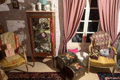 trois chaises et une table dans une pièce aux rideaux roses