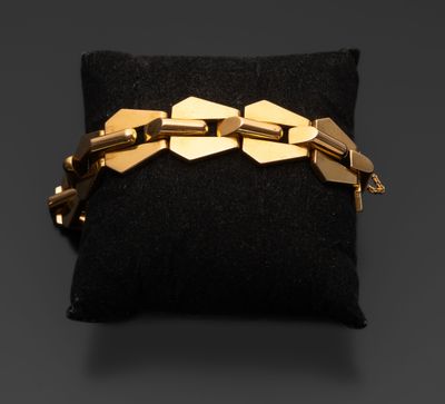 un bracelet en or posé sur un coussin noir