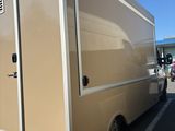 an image of a beige food truck parked in a parking lot