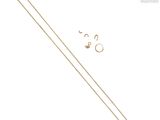 un gros plan sur une chaîne en or à laquelle sont accrochées une paire de boucles d'oreilles