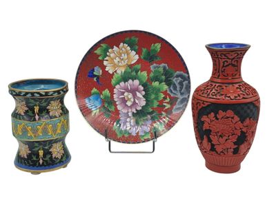 three vases and a plate sitting on a stand