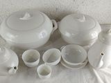 a lot of white dishes and cups sitting on a table