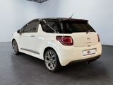 the rear end of a small white car parked in a garage