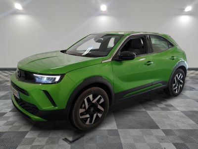 un SUV vert garé dans une pièce au sol carrelé