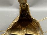 gold plated lamp with a bird on top of it on a table